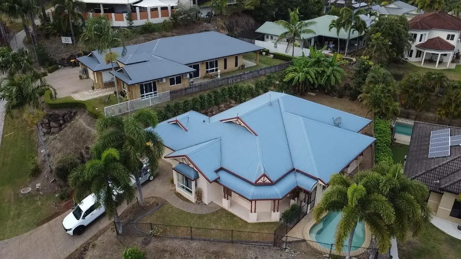 Drone photograph of a Cairns home with a blue tiled roof, viewed from above
